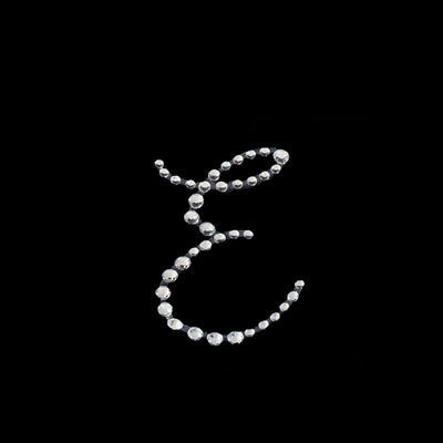Rhinestone letter "E" design on a black background.