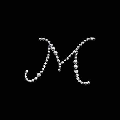 Rhinestone letter M design on a black background.