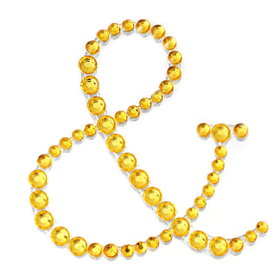 Yellow rhinestone ampersand decoration on white background.