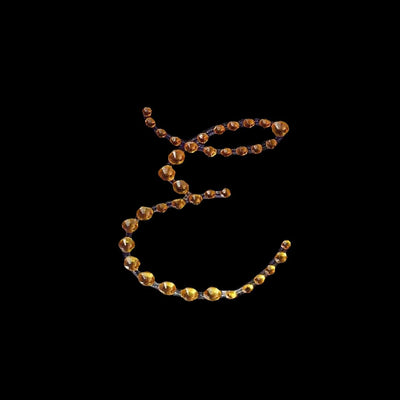 Elegant amber bead necklace on a dark background.