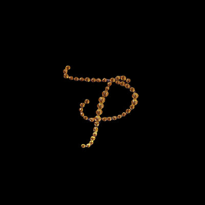 Gold bead letter "P" design on a black background.