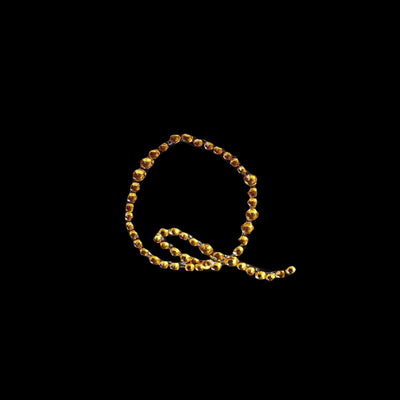 Gold beaded necklace with intricate design on black background.