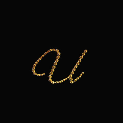 Gold "Au" letter formed with beads on a black background.