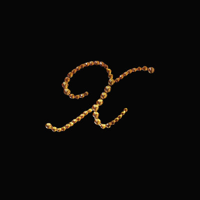 Golden letter "R" made of beads on a black background.