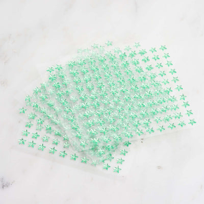 Green star-shaped stickers on transparent sheets