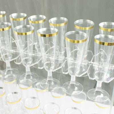 Clear champagne flutes with gold rims arranged in a display rack.