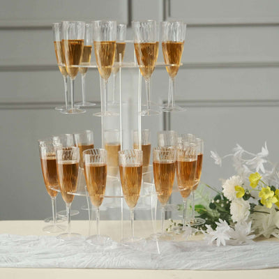 Champagne flutes arranged elegantly on a tiered stand with floral accents.