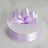 Purple satin ribbon with a bow on a white spool.