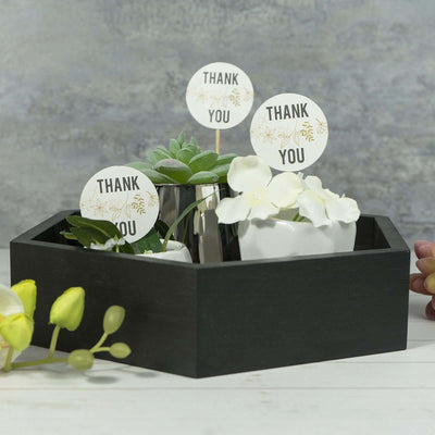 Decorative black planter with succulents and "Thank You" signs.