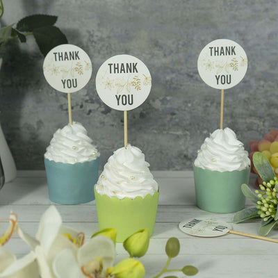 Colorful cupcakes with "Thank You" toppers on a decorative table setting.