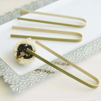 Bamboo tongs on a decorative platter with dessert