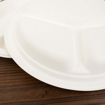 White disposable plate stacked on a wooden surface.