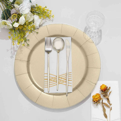 Elegant gold cutlery set on a textured plate with decorative napkin and table decor.
