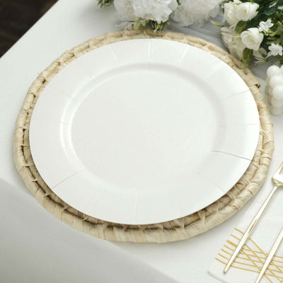 White disposable plate on a woven placemat with elegant table setting.