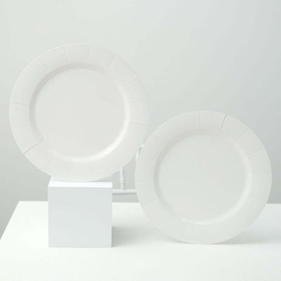 Two white plates on a pedestal against a plain backdrop.