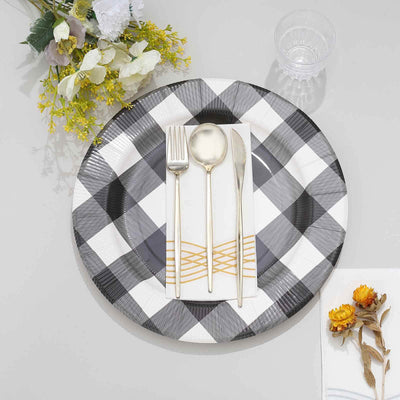 Elegant black and white checkered plate set with gold utensils and floral accents.