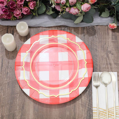 Red and white checkered plate on a wooden table with candles and cutlery.