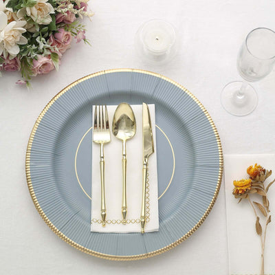 Elegant table setting with gold cutlery on a blue plate.