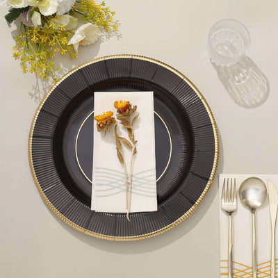 Elegant table setting with black plate, floral napkin, and cutlery.