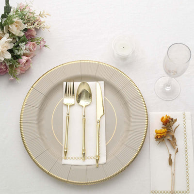 Elegant table setting with gold-accented cutlery and decorative plate.