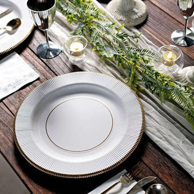 Elegant white plate with gold rim on a rustic wooden table setting.