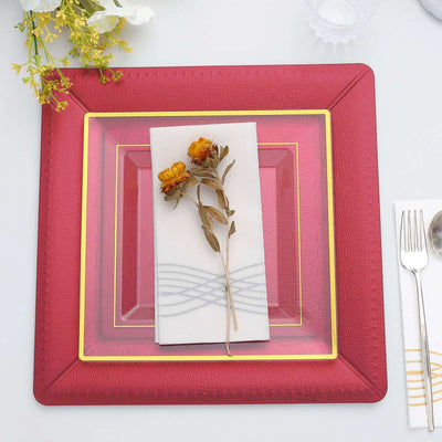 Elegant red decorative plate with napkin and dried flowers on a table setting.