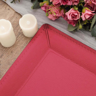 Red textured serving tray on a wooden surface with candles and flowers.