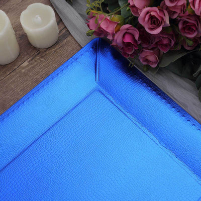 Blue textured serving tray with roses and candles on a wooden surface.