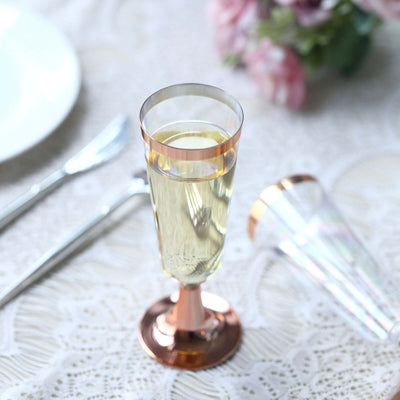 Elegant champagne flute with a rose gold base on a textured table setting.