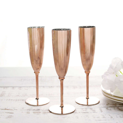Rose gold champagne flutes set of three on a white background