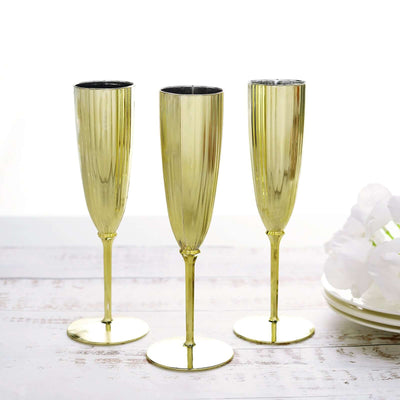 Set of three elegant gold champagne flutes on a white background