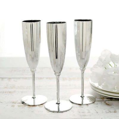Set of three elegant silver champagne flutes on a white background.