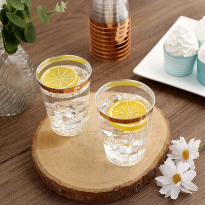 Two clear glasses filled with water and lemon slices on a wooden surface.