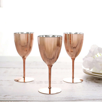 Set of three elegant rose gold wine glasses on a table.