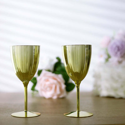 Elegant gold wine glasses on a wooden table with floral background.