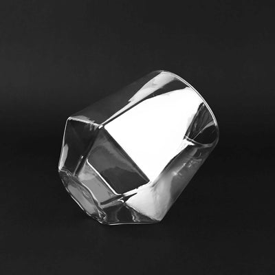 Faceted glass tumbler on a black background.