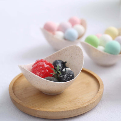Dessert bowl with red sorbet and berries on a wooden tray.