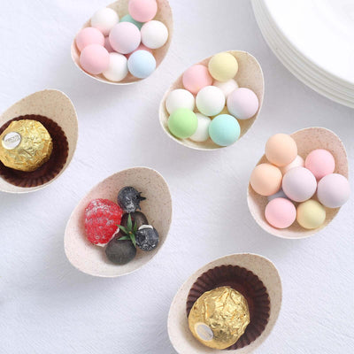 Colorful candies in decorative egg-shaped bowls on a white background.