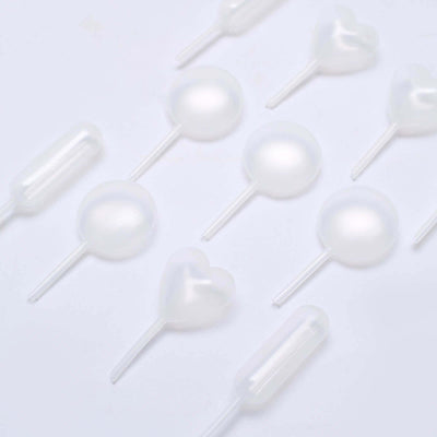 Clear plastic droppers and pipettes in various shapes on a white background