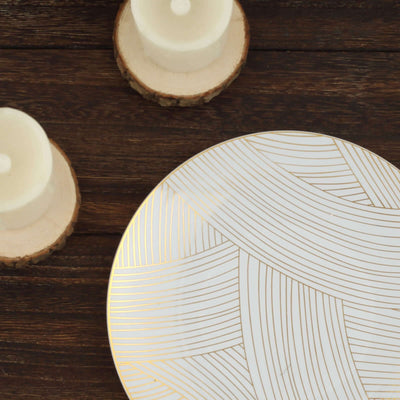 Decorative white plate with gold linear design on wooden table