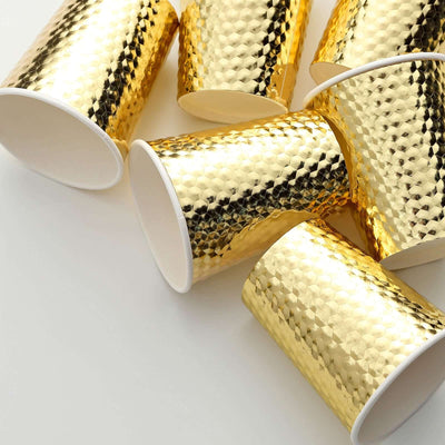 Gold textured paper cups stacked on a white background.