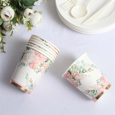 Floral disposable cups stacked with elegant gold accents on a table setting.