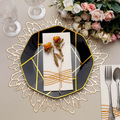Elegant black plate with gold accents, floral decoration, and stylish cutlery setting.