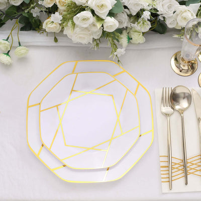 Elegant geometric gold and white dinner plate set on a table with floral arrangement.
