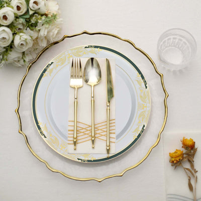 Elegant decorative plate with gold trim and utensils on a white table setting.
