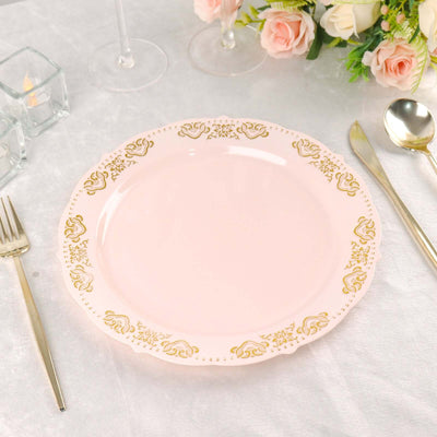 Elegant pink plate with gold floral trim on a textured table setting.