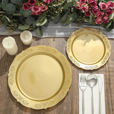 Elegant gold plates set with floral accents and candles on a rustic wooden table.