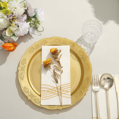 Elegant gold plate with floral napkin, cutlery, and glass, styled for dining.
