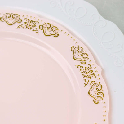Elegant pink plate with gold floral design and white trim.
