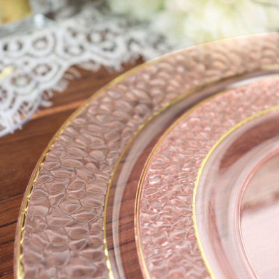 Elegant pink glass plates with gold rim accents on a wooden surface.